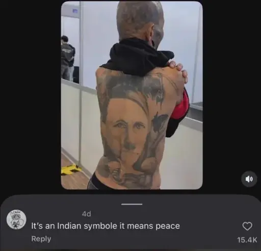 A man with tattoes covering his bald head and torso shows the camera his large anime-style hitler portrait tattoo on his back. / an instagram comment read: "It's an indian symbole it means peace"