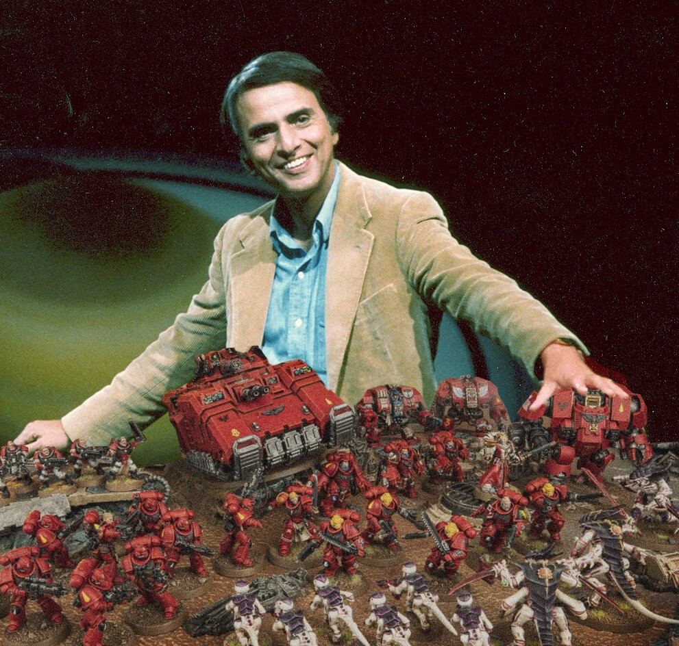 Carl Sagan fielding a Space marine army against a Tyarind one in the WH40K tabletop game.