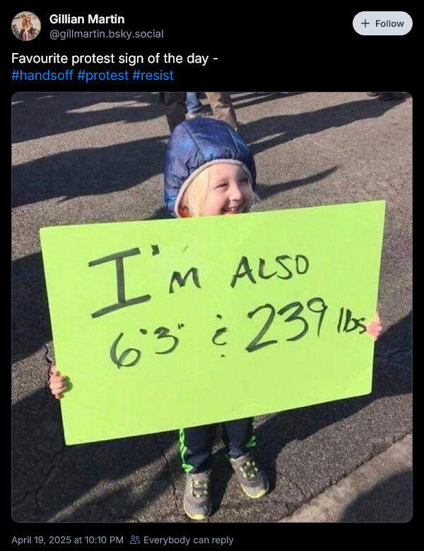 A post on Blue Sky by Gillian Martin announcing her favourite protest sign of the day and a photo showing a small child holding a sign that reads "I'm also 6 foot 3 and 239 pounds"